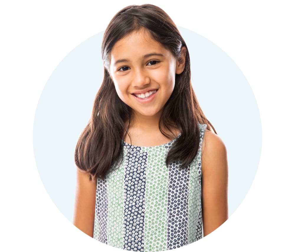 Young girl with brown hair smiling at the camera.