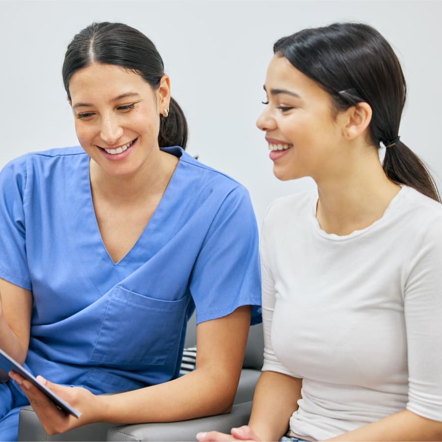 Dentist discussing treatment with a patient while reviewing information on a clipboard.
