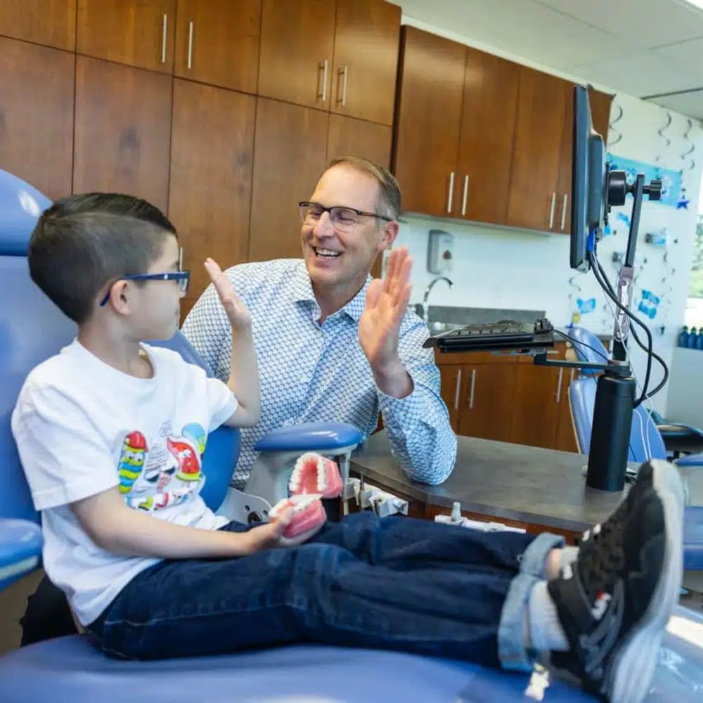 Dr. Cory Liss and a young patient high fiving
