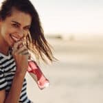 Smiling woman drinking a soft drink