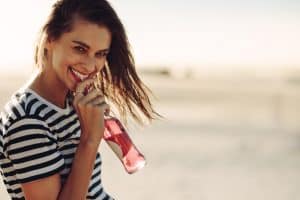 Smiling woman drinking a soft drink